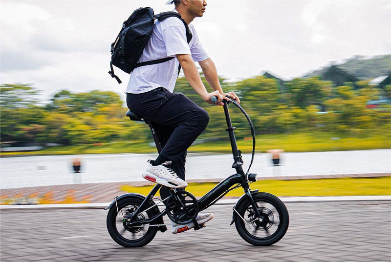 A man travelling on a Fiido D3 Pro e-bike on a brick paved road