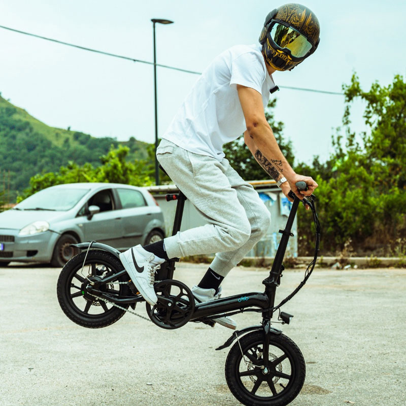 A man wearing a helmet cocked the rear of a Fiido D3 Pro e-bike